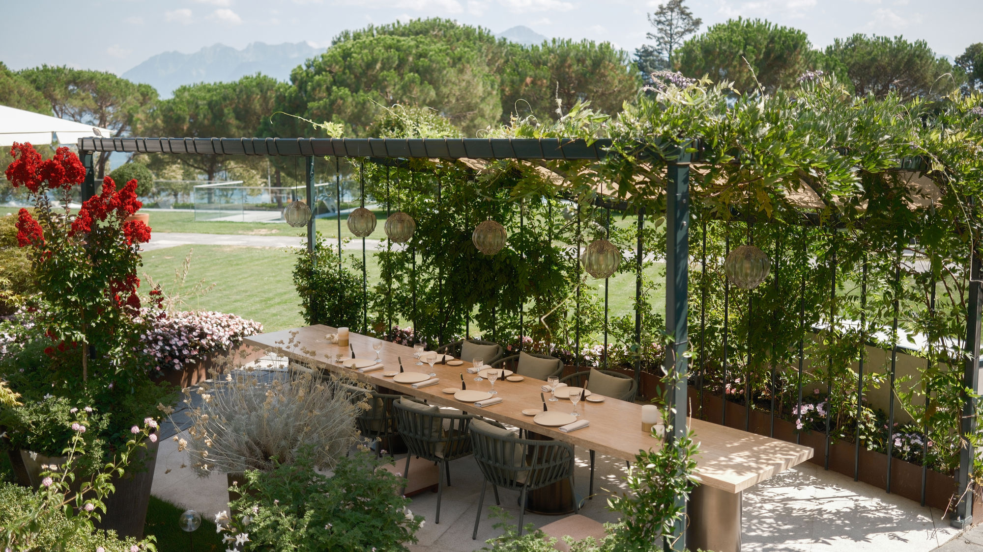 Grande table sur la terrasse du restaurant Anne-Sophie Pic au Beau-Rivage Palace Lausanne face aux jardins et au lac Léman, expérience gastronomique en plein air, art de vivre et élégance dans un hôtel de luxe et palace 5 étoiles à Lausanne Ouchy