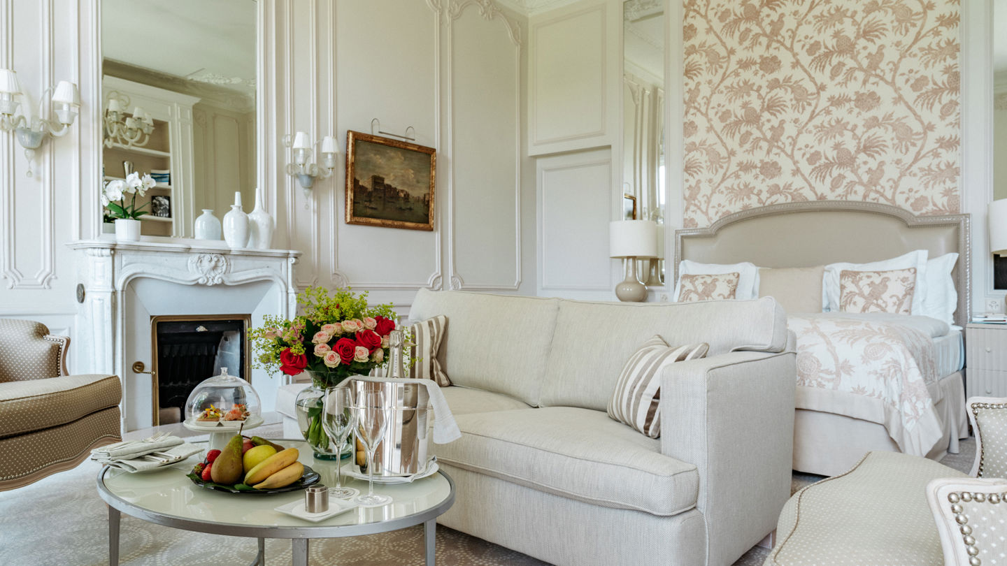 Bedroom and lounge area with welcome amenities in the Junior Suite Palace Ground Floor Room at Beau-Rivage Palace in Lausanne