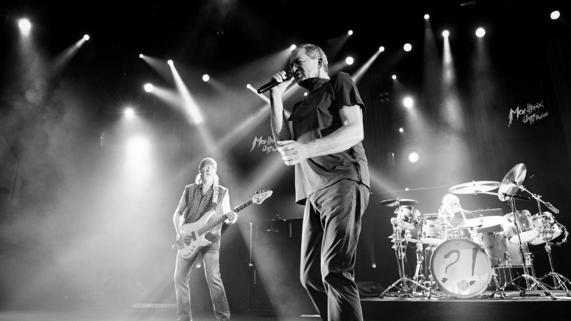 Group of artists performing live on stage at the Montreux Jazz Festival, illuminated by dramatic concert lighting in front of an engaged audience. Photograph by Georges Braunschweig.