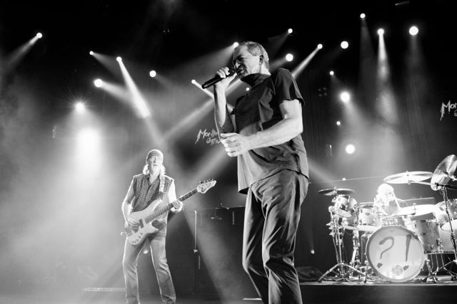 Group of artists performing live on stage at the Montreux Jazz Festival, illuminated by dramatic concert lighting in front of an engaged audience. Photograph by Georges Braunschweig.