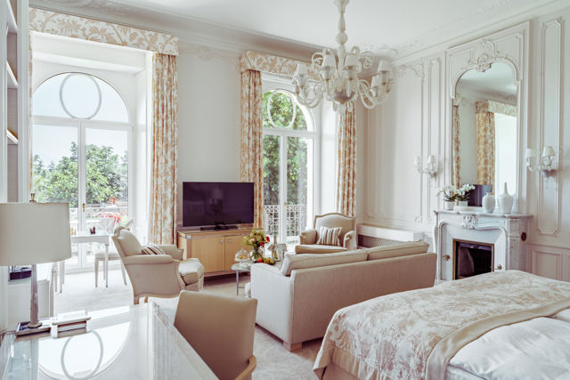 Bedroom and lounge area in the Junior Suite Palace Ground Floor Room at Beau-Rivage Palace in Lausanne overlooking the gardens, the lake and the Alps