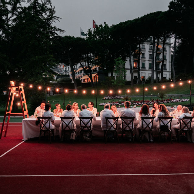 Elegant dinner on the court evening at Beau-Rivage Palace in Lausanne, a white dinner on the tennis court in the gardens with a jazz-swing atmosphere