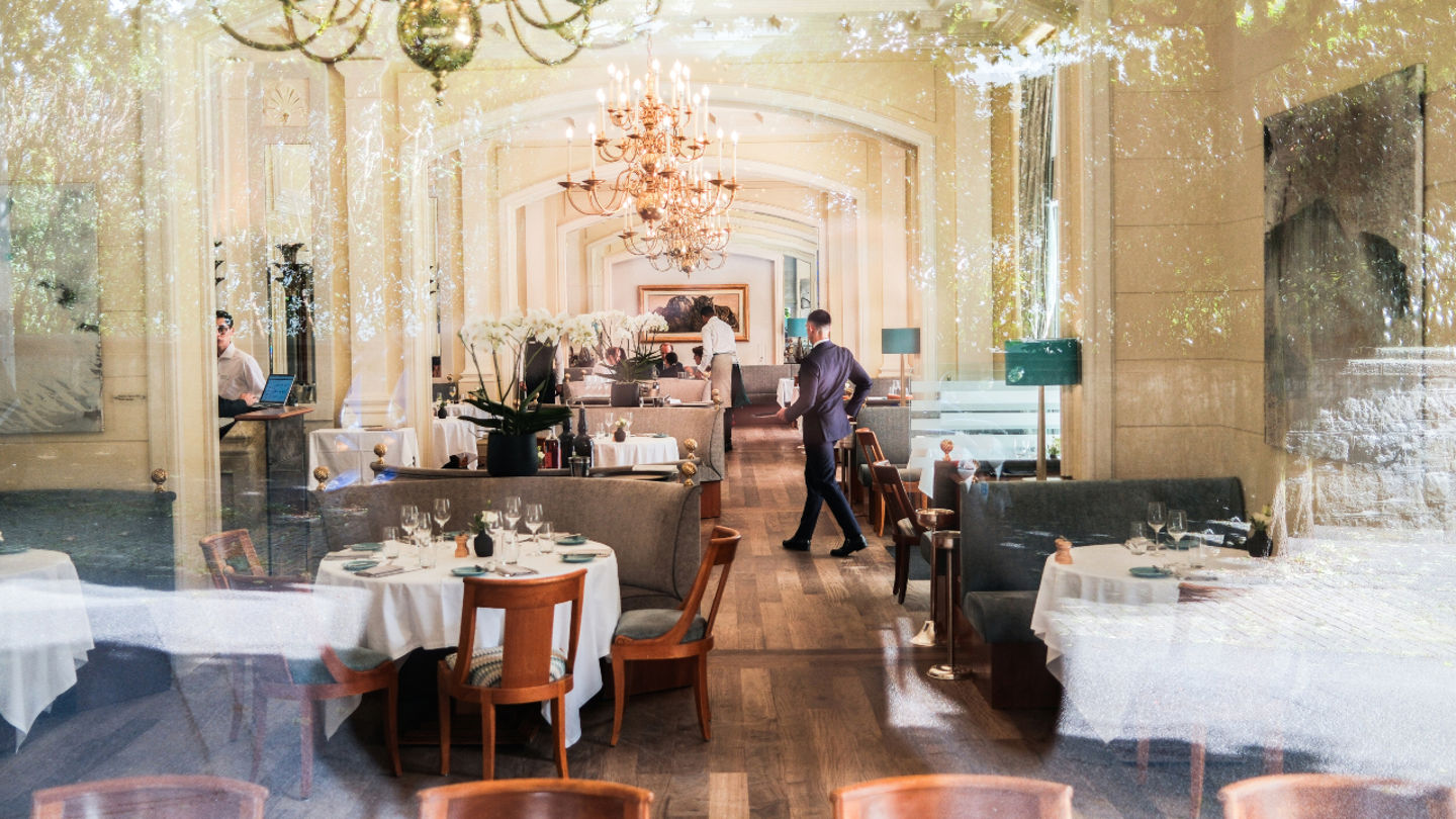 Vue du restaurant Café Beau-Rivage au Beau-Rivage Palace Lausanne avec ambiance élégante et lumière naturelle au bord du lac Léman, expérience gastronomique dans un hôtel de luxe à Lausanne et palace 5 étoiles à Lausanne Ouchy