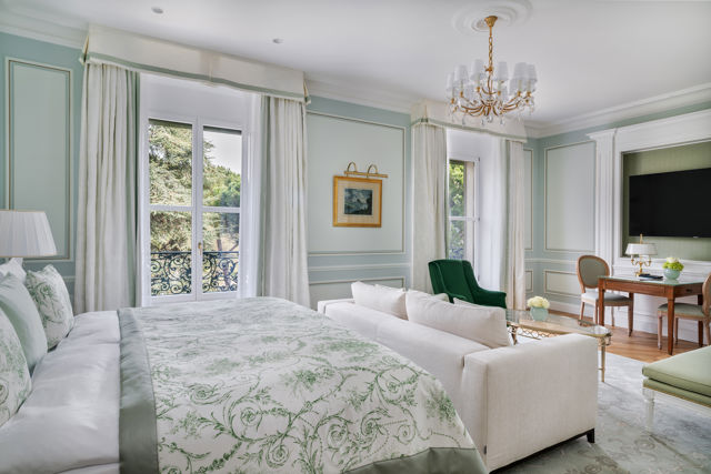 Bedroom and lounge area in the Deluxe City and Garden View Room at Beau-Rivage Palace in Lausanne overlooking the gardens